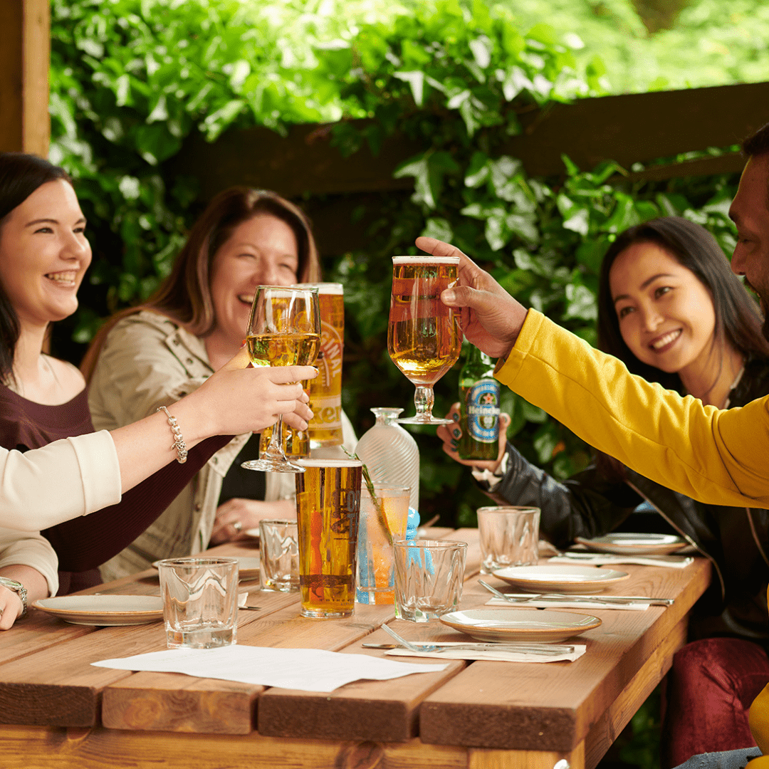 A few people in the pub garden raising a cheers