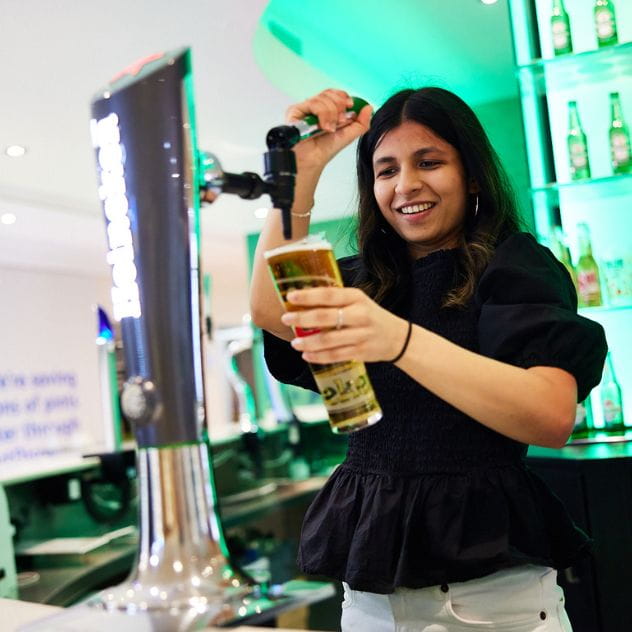 Colleague pouring Pint of HEINEKEN 0.0 at office bar